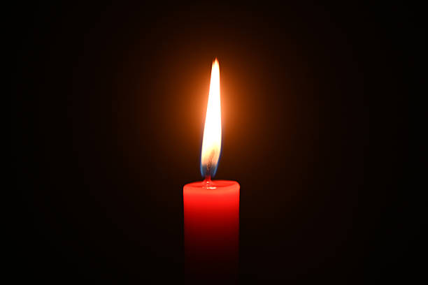 istock Close-up of a burning candle in a dark background 2218984733