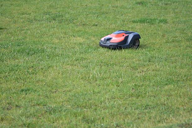 istock Autonomous robotic lawn mower working on a grass. Smart garden technology for effortless lawn care. Eco-friendly, time-saving solution for modern landscaping and outdoor maintenance. 2218991588