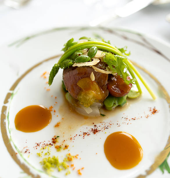 Elegant vegetarian dinner with smoked tofu, potatoes, pumpkin sauce, onion and seaweed