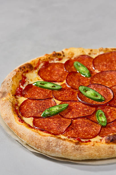 istock Classic pepperoni pizza with rustic crust and vibrant overhead lighting on neutral background 2218993290