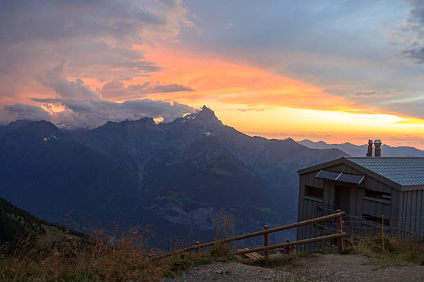 Mountain panorama with alpine hut Cabane de la Tourche, mountain range Dents du Midi and red sunset with burning sky and alpenglow in Swiss Alps, Switzerland