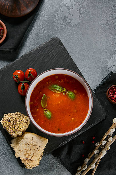 istock Vegan menu gazpacho with basil, dramatic overhead lighting, dark slate composition, modern editorial food style 2218996897
