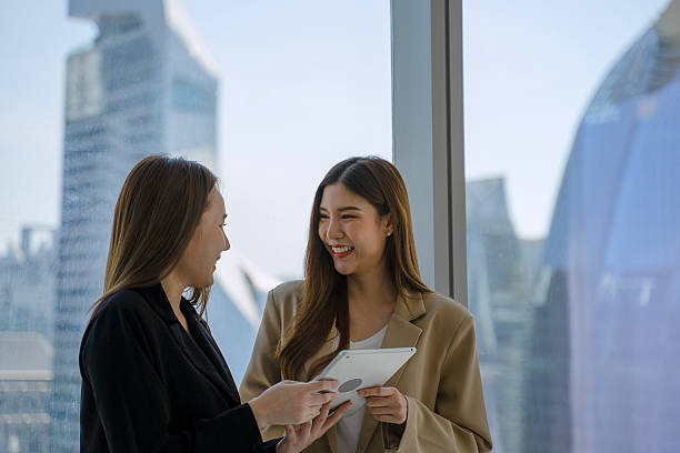 istock Female white collar workers are working with digital tablet at high rise office building. 2219007016