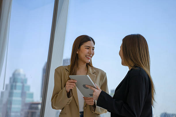 istock Female white collar workers are working with digital tablet at high rise office building. 2219007026
