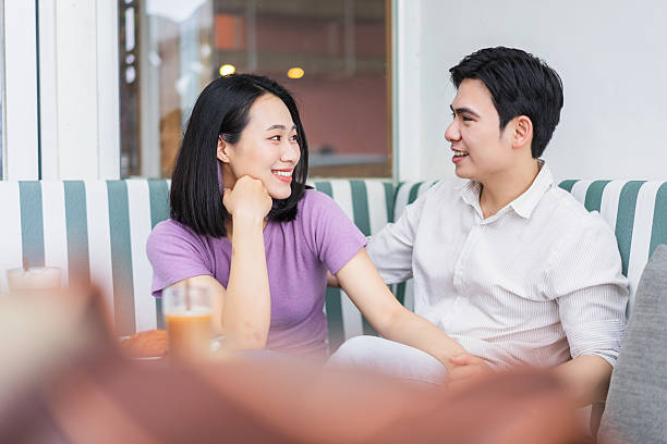 istock Young couple enjoying a cozy conversation at a cafe in a modern setting during late afternoon 2219011871