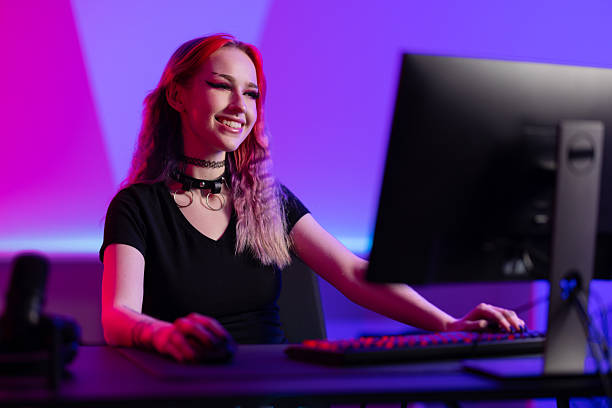 istock Smiling gamer enthusiast working at a computer in a colorful gaming setup 2219013862