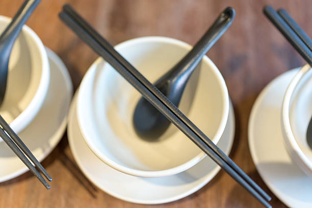 Empty white bowls, black chopsticks and black spoon. Top view