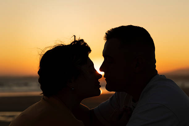 istock Couple sharing intimate moment at sunset on beach 2219019150
