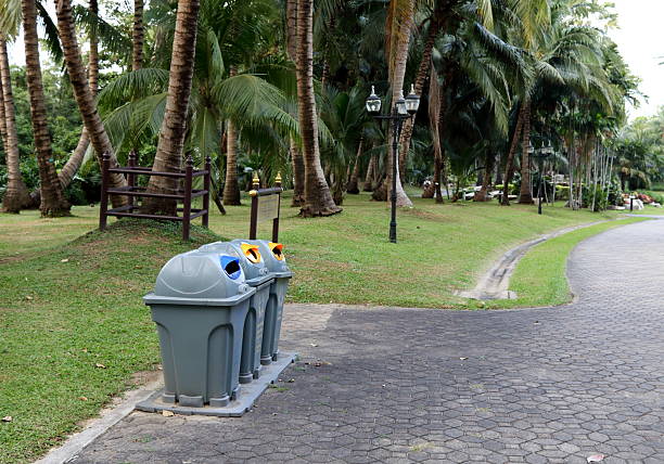 trashcan stands against a white wall, overflowing with crumpled papers, symbolizing waste and clutter