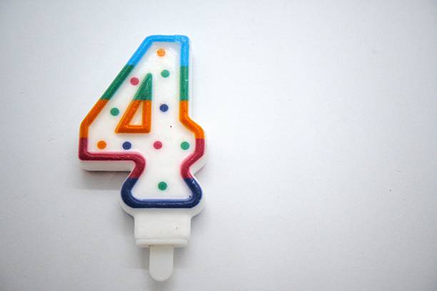 Number 4 birthday candle close up with white background.