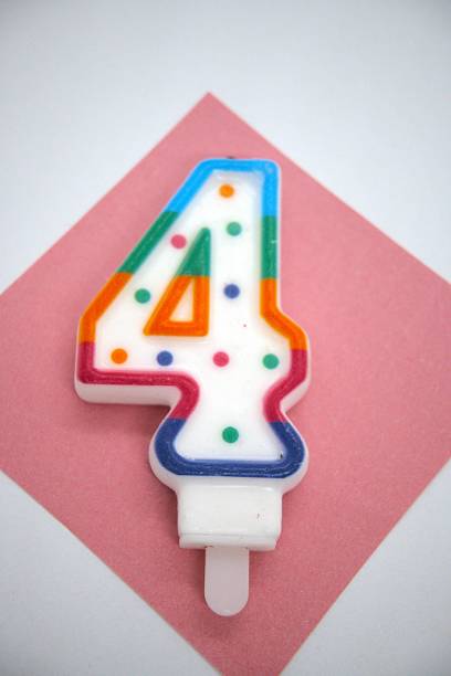 istock Number 4 birthday candle close up with white background. 2219019645