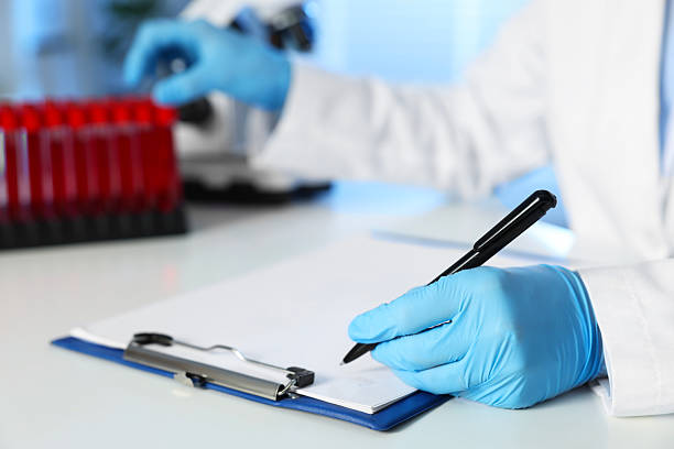 istock Laboratory testing. Doctor taking test tube with blood sample while working at table indoors, closeup 2219021162