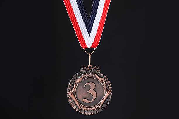 Bronze medal with striped ribbon on black background