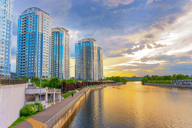 Kyiv, Ukraine - May 19, 2025: Panoramic view of the RiverStone residential complex in Kyiv, Ukraine, featuring modern high-rise buildings beside a calm river at sunset.
