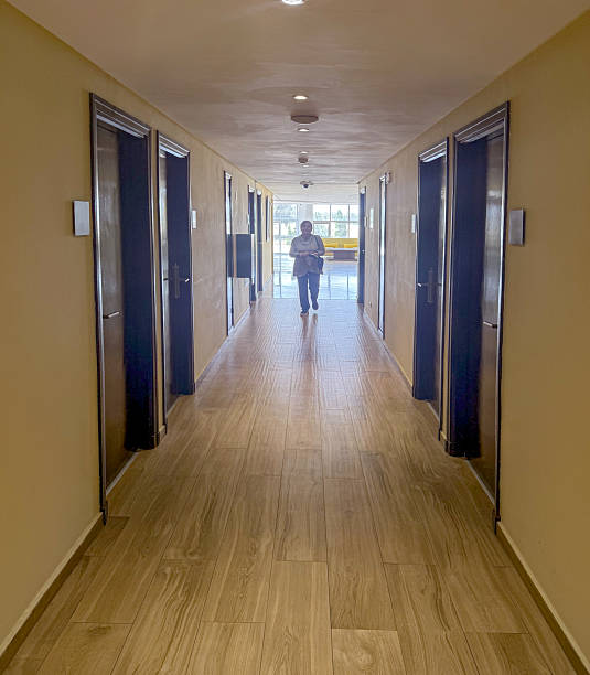 Senior woman walking down illuminated corridor