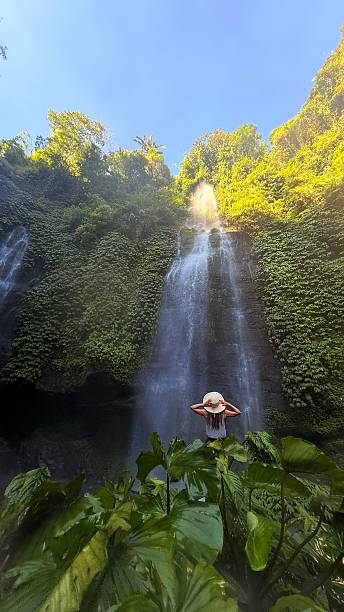 istock A woman standing under the waterfall in Bali. 2219036335