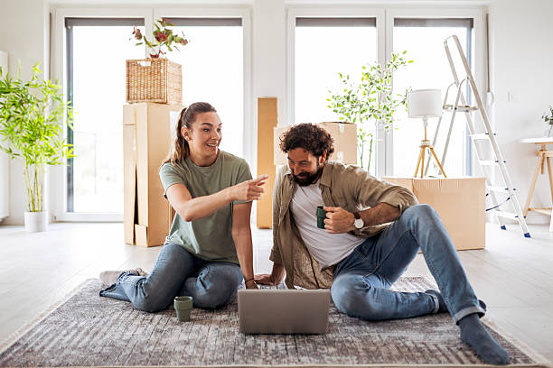 istock Couple on Moving Day Using Laptop to Organize Their Home 2219037531