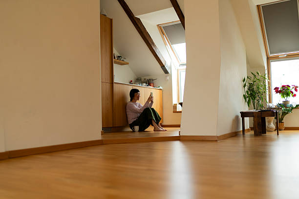 istock Woman relaxing on floor using smartphone in modern apartment 2219040015