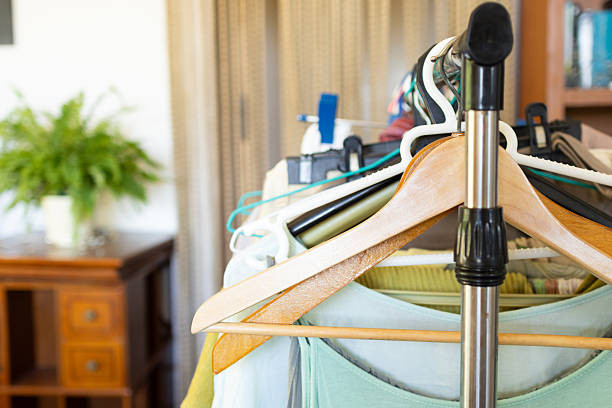 Hanging garments on a metal clothes rack, featuring wooden and plastic hangers, creates an organized scene reflecting everyday domestic life and efficient wardrobe management