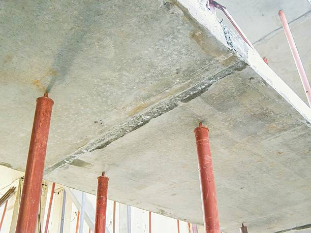 istock Concrete slab construction showing metal support pillars and the rough surface in detail from an upward angle. 2219045833