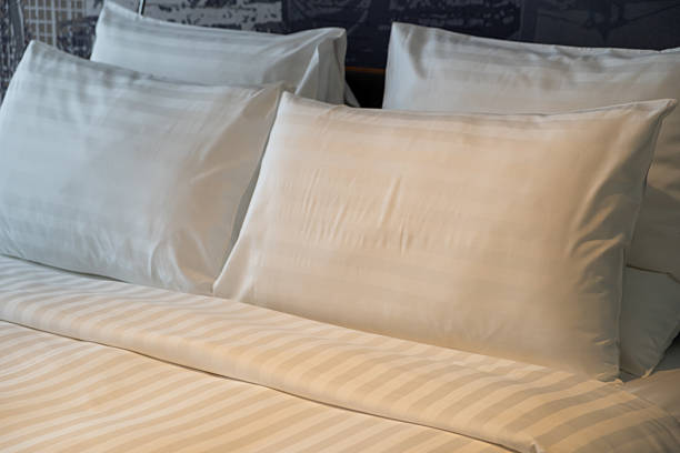 istock A neatly made hotel bed with soft pillows with warm reading light 2219046256