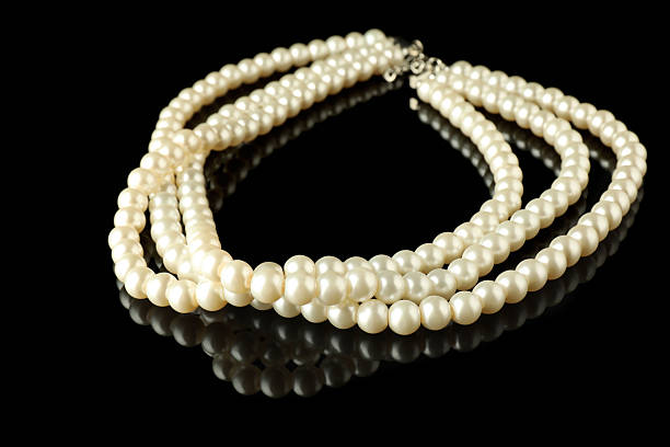 istock Beautiful bijouterie. Elegant necklace on black mirror surface, closeup 2219047943