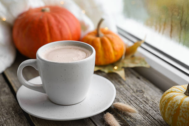 istock Cup of coffee and autumn decor on window sill, closeup 2219048268