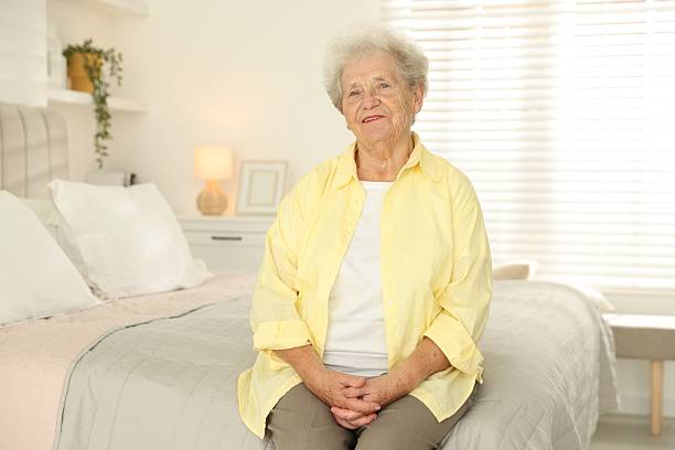 istock Beautiful senior woman sitting on bed at home 2219049310