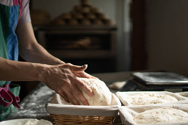Baker shaping dough for baking in a basket