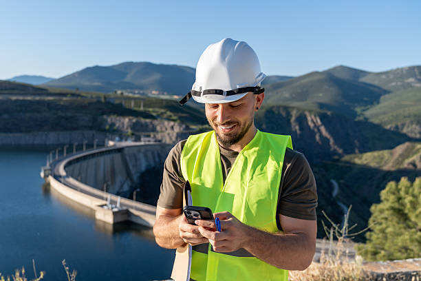 istock Quality controller using smartphone near hydroelectric power plant dam 2219052388
