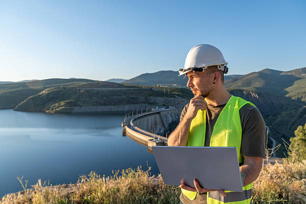 istock Engineer inspecting a dam with laptop at sunset 2219052933