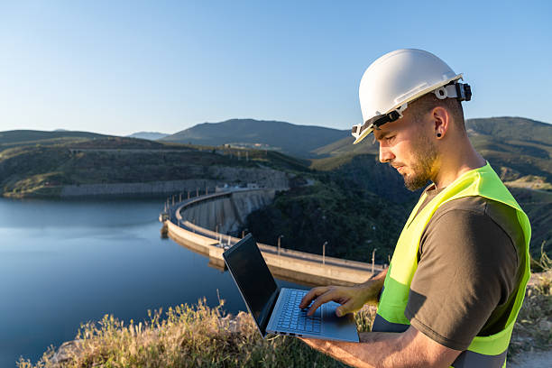 istock Engineer working with laptop near hydroelectric power plant dam 2219052975