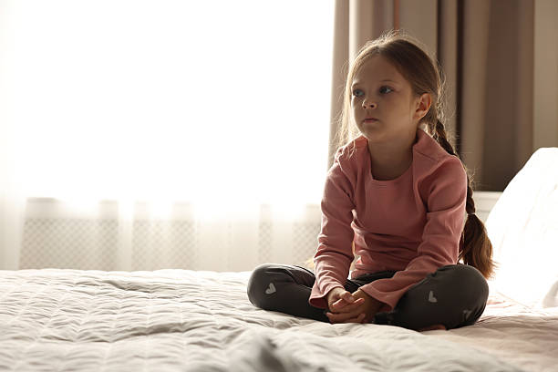 istock Orphanage concept. Sad girl on bed in room 2219054913