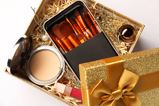 istock Makeup brushes, decorative cosmetics and Christmas decor in box on white background, top view 2219055030