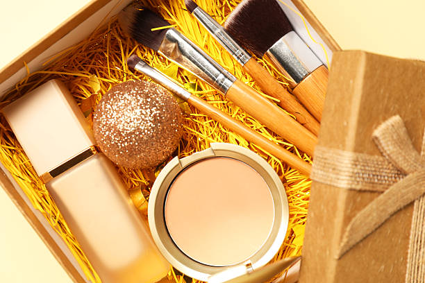 istock Makeup brushes, decorative cosmetics and Christmas decor in box on yellow background, top view 2219055060