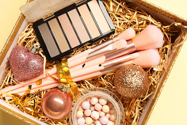 istock Makeup brushes, blush and Christmas decor in box on yellow background, top view 2219055090