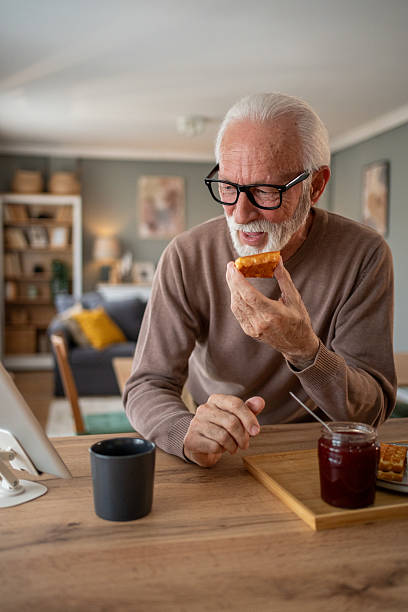 istock Senior man enjoying breakfast and reading news on tablet 2219055207