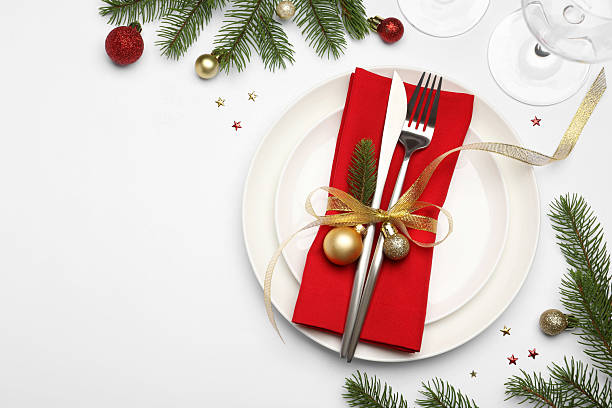 istock Christmas table setting with plate, cutlery, napkin, glasses and festive decor on white background, flat lay. Space for text 2219055281