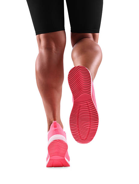 Close up feet of a running man. Selected focus on running shoes with black and green glow sole. front view, isolated on white image.