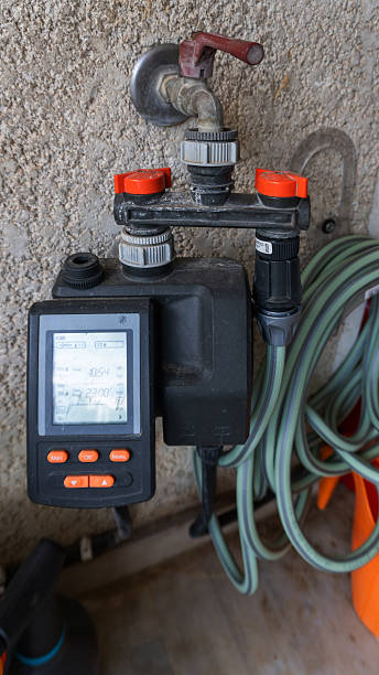 istock Automatic irrigation system on the plaster wall and green hose for water 2219055930