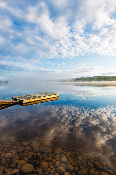 istock Tranquil jetty on a still lake in Sweden with reflections and morning mist 2219060923