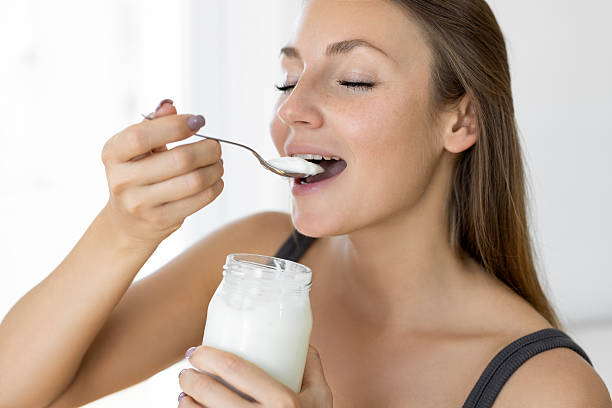 istock Beautiful female eating yoghurt 2219063344