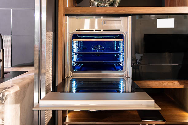 istock Built-in stainless wall oven with blue light in walnut kitchen 2219063397