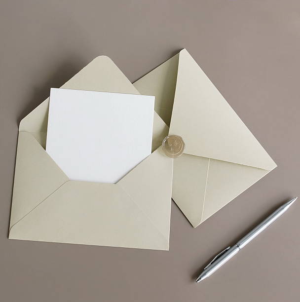 istock Beige envelope with blank paper card mockup inside top view on beige background . Copy space. 2219065402