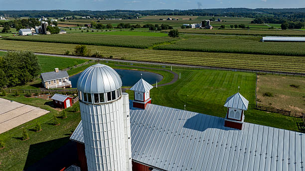 istock Barn Overlooking Lush Farmland With Distant Hills and Clear Sky 2219067523