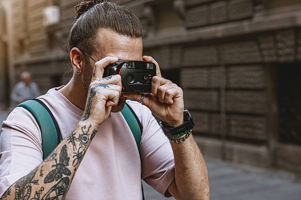istock Man taking photos with a old camera outdoors in the city 2219069928