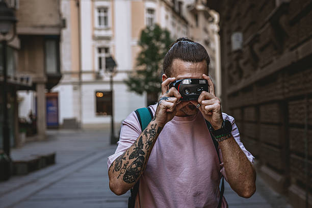 istock Man taking photos with a old camera outdoors in the city 2219069949