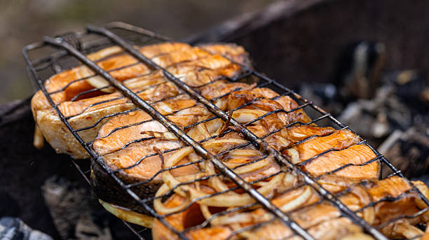 Savor the incredibly delicious grilled salmon steaks accompanied by perfectly cooked onions, a true delight