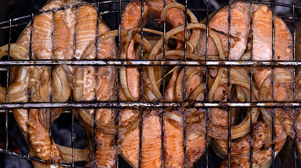 Savor the incredibly delicious grilled salmon steaks accompanied by perfectly cooked onions, a true delight