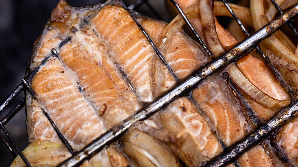 Savor the incredibly delicious grilled salmon steaks accompanied by perfectly cooked onions, a true delight